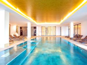 a pool in a hotel with chairs in a room at Dream holiday apartment with pool sauna MB in Börgerende-Rethwisch