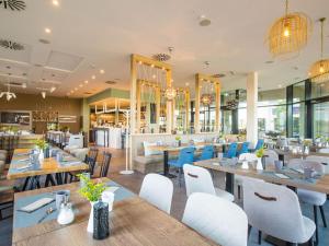 a restaurant with wooden tables and white chairs at Dream holiday apartment with pool sauna MB in Börgerende-Rethwisch