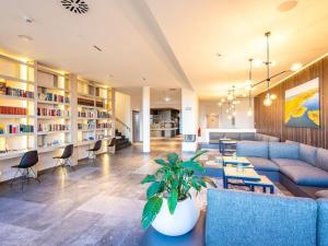 a living room with a couch and tables and chairs at Dream holiday apartment with pool sauna MB in Börgerende-Rethwisch