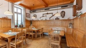 a dining room with wooden tables and chairs at Hotel Forchhammer in Pliening