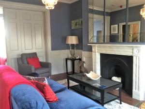 a living room with a blue couch and a fireplace at Hewlett Apartments in Cheltenham