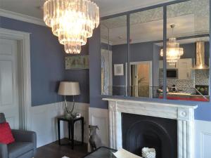 a living room with a fireplace and a mirror at Hewlett Apartments in Cheltenham +37 photos