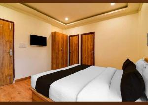 a bedroom with a white bed and a television at Super Collection O Raj Guest House Near Kolkata Airport in Kolkata +59 photos