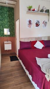 een slaapkamer met een rood bed en een wastafel bij chale bella serra in Jaboticatubas