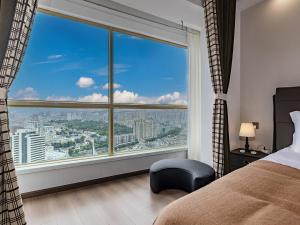 1 dormitorio con ventana grande con vistas a la ciudad en Annie 公寓-2602, en Kunming