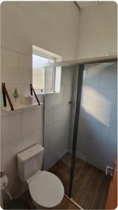 een kleine badkamer met een toilet en een raam bij chale bella serra in Jaboticatubas