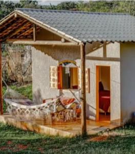 een klein huis met een schuin dak en een patio bij chale bella serra in Jaboticatubas