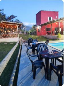 een rij tafels en stoelen naast een zwembad bij chale bella serra in Jaboticatubas +15 foto's
