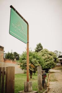 un cartello stradale verde su un palo nell'erba di Pousada Novo Horizonte a São Francisco de Paula Altre 19 foto