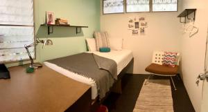 een kleine kamer met een bed en een stoel bij OnNut Pool Homestay in Amphoe Phra Khanong +10 foto's