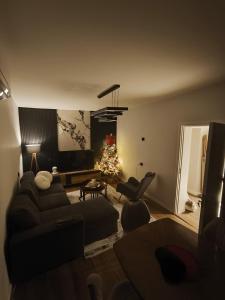 a living room with a couch and a christmas tree at Pri Home in Pristina