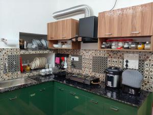 a kitchen with green cabinets and a counter top at Eden Casa in Mararikulam