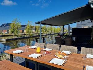 a wooden table with food on top of a balcony at Luxurious detached water villa with jetty in Balk