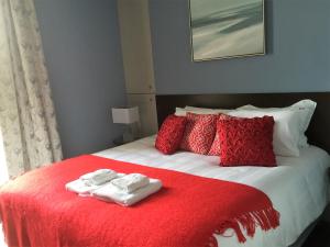 a bed with red and white towels on it at Hewlett Apartments in Cheltenham