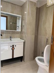 un bagno con un water, un lavandino e uno specchio di Best Inn Hotel a Murree