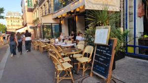 a restaurant with tables and chairs on a sidewalk at Center ,gare Montparnasse,5 minute Eiffel tout and Louvre Meusm,amusing place in Paris +15 photos