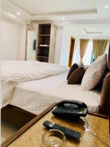 un letto con un telecomando su un tavolo di Best Inn Hotel a Murree