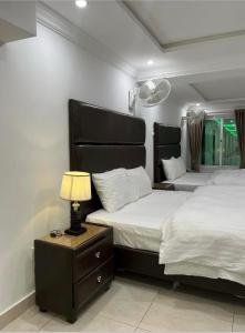 una camera da letto con due letti e una lampada sul comodino di Best Inn Hotel a Murree