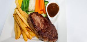 einen Teller mit einem Steak und Pommes frites in der Unterkunft Wondai Colonial Motel & Ivory's Restaurant in Wondai