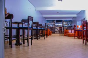 a restaurant with chairs and tables and a bar at NOAZ Hotel Kampala in Kampala