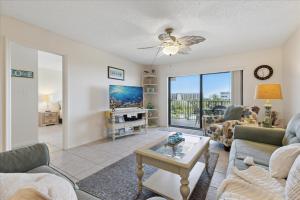 een woonkamer met een bank en een tafel bij Windrush 509 in Cocoa Beach