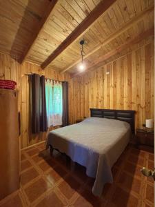 una camera da letto con un letto in una stanza di legno di Cabañas Troncos de Relin a Panguipulli Altre 56 foto