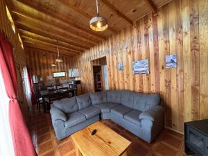 un soggiorno con un divano e un tavolo di Cabañas Troncos de Relin a Panguipulli