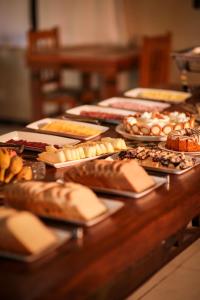 un tavolo con tanti tipi diversi di pane e dolci di Pousada Novo Horizonte a São Francisco de Paula