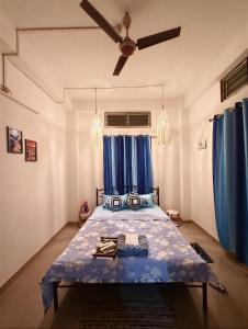 Un dormitorio con una cama con cortinas azules. en Hestia by Ghorsirika, en Guwahati