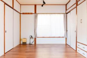 an empty room with a large window and wooden floors at ふとの情景 Futo Nostalgia in Ito +35 photos