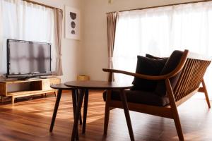 a living room with a chair and a table and a tv at ふとの情景 Futo Nostalgia in Ito