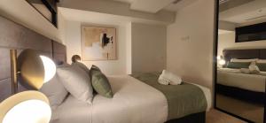 um quarto com uma grande cama branca e um espelho em Absolute Collins Apartments em Melbourne