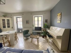 a living room with a couch and a piano at Charmant T2 Larressore - Parking Privé - WiFi Inclus - FR-1-495-156 in Larressore +8 photos