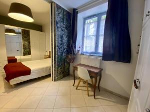 a bedroom with a bed and a desk and a table at Charmant T2 Larressore - Parking Privé - WiFi Inclus - FR-1-495-156 in Larressore