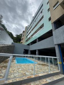 une piscine devant un bâtiment dans l'établissement Apartamentos das Toninhas, à Ubatuba