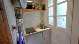 Una pequeña cocina con fregadero y ventana. en 12 Lovely Studio Steps from Boulevard Saint Germain, en París 8 fotos más