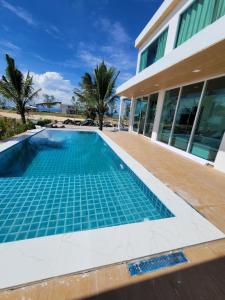 una piscina vuota di fronte a una casa di The wide pool villa trat a Ban Nong Wiwat