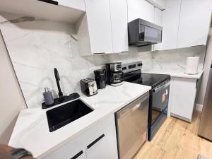 a white kitchen with a sink and a stove at NorthEdge Suites in Edmonton