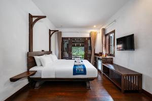 Postel nebo postele na pokoji v ubytování Ancient Luangprabang Hotel