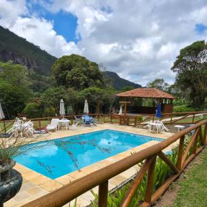 ein Schwimmbad mit einem Holzzaun in der Unterkunft Chalé com vista deslumbrante in Teresópolis + 90 Fotos