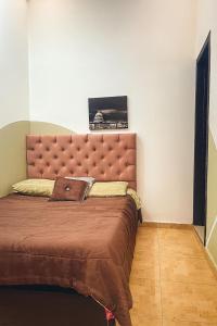 波哥大A 5 minutos de Aeropuerto Dorado的一间卧室配有一张大床和棕色床头板