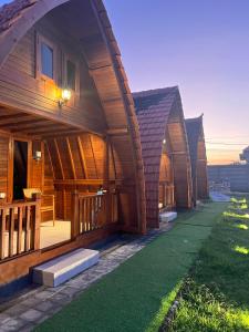 Villa Aiden Bungalow 1 Familiale Ungasan في أونغاسان: صف من الاكواخ الخشبية على التوالي