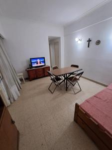 a living room with a table and a tv at Tucumán y Colón in Mar del Plata