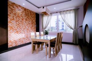 a dining room with a table and chairs and a brick wall at Kegotel Luxury Villa - Bãi Tắm Long Cung in Vung Tau