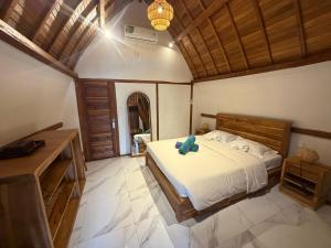 a bedroom with a bed with a blue pillow on it at Villa Aiden Bungalow 2 near Beach in Ungasan +22 photos