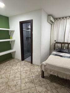 una camera con letto e porta doccia in vetro di Casa vacacional con piscina a Búzios