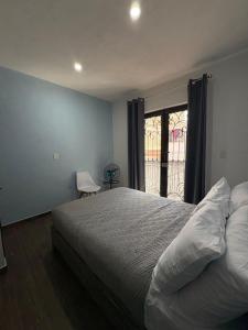 een slaapkamer met een groot bed en een raam bij Silver Mountain House in Taxco de Alarcón +11 foto's