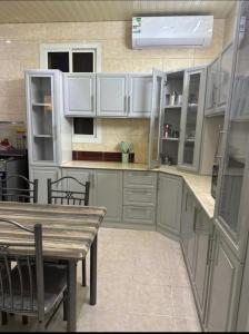 una cucina con mobili bianchi e un tavolo di legno di عقارات سام-Sam Rental a Medina Altre 4 foto