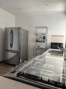 een keuken met een roestvrijstalen koelkast en een spoelbak bij Silver Mountain House in Taxco de Alarcón