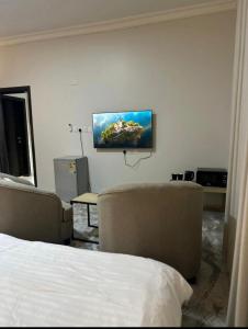 Camera con letto e TV a schermo piatto a parete di عقارات سام-Sam Rental a Medina